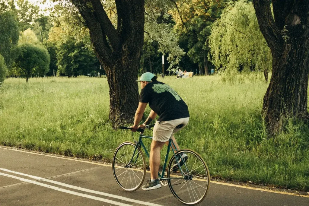 Person cyklar på en gång- och cykelväg i en park